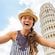 A woman smiling with her arms outstretched in front of the Leaning Tower of Pisa